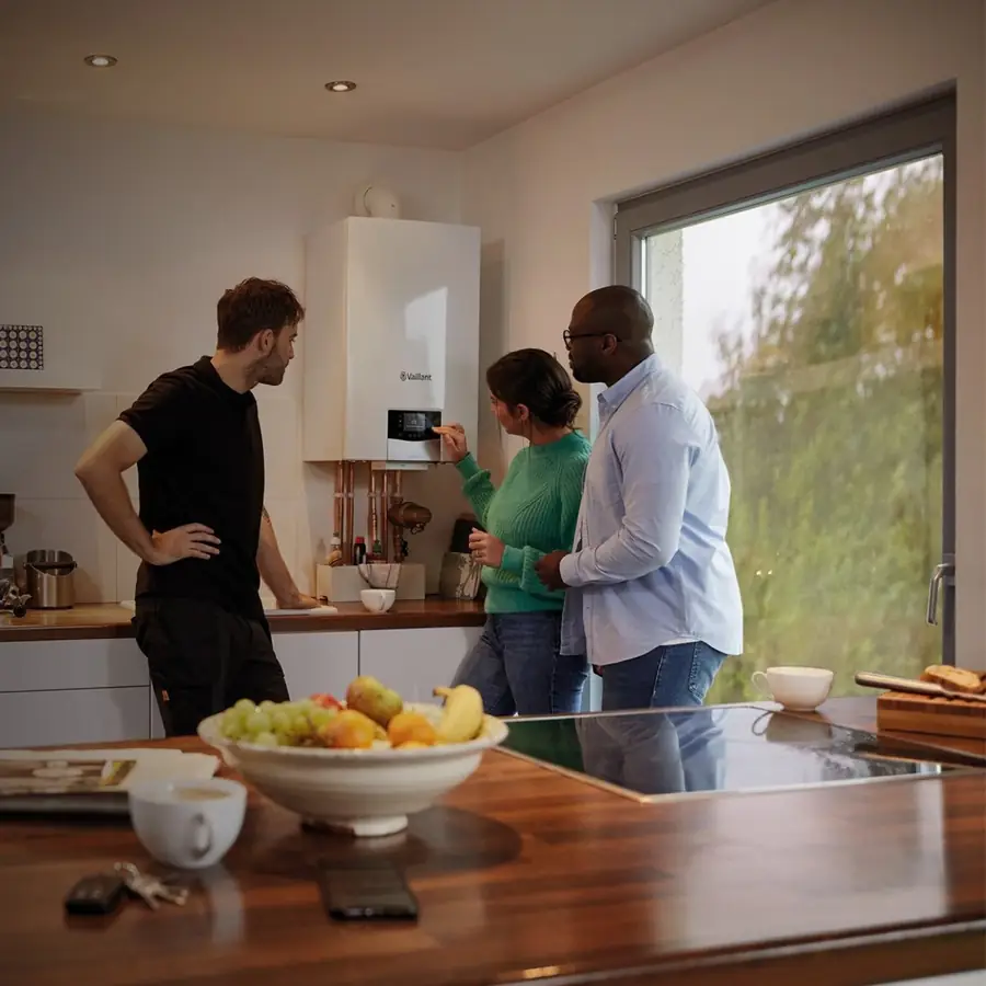 Engineer showing a couple their new Vaillant boiler in a London kitchen